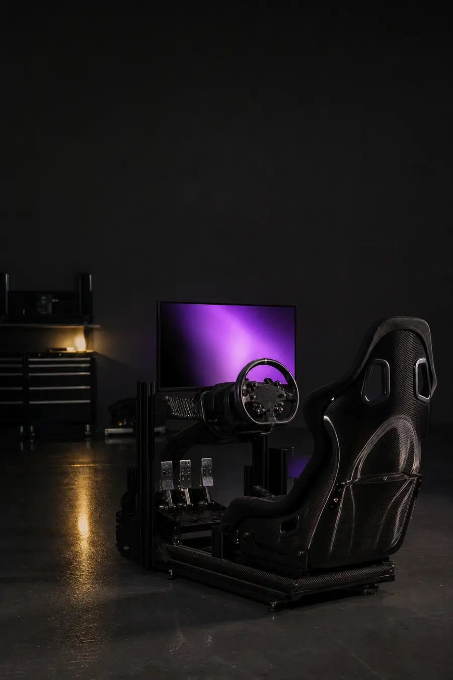A sim racing rig in a race garage at night.