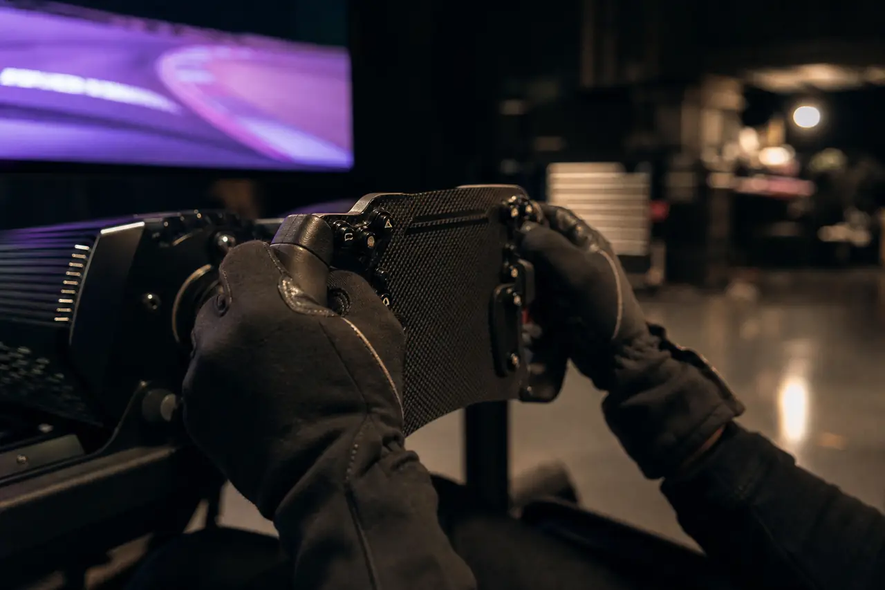 Gloved hands gripping a sim racing wheel.
